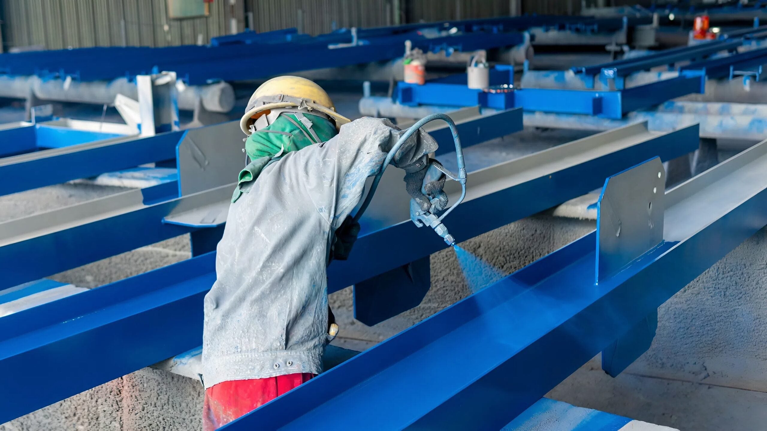 Protective blue coating applied to structural steel beams inside an industrial facility by an industrial painter in Tampa, FL